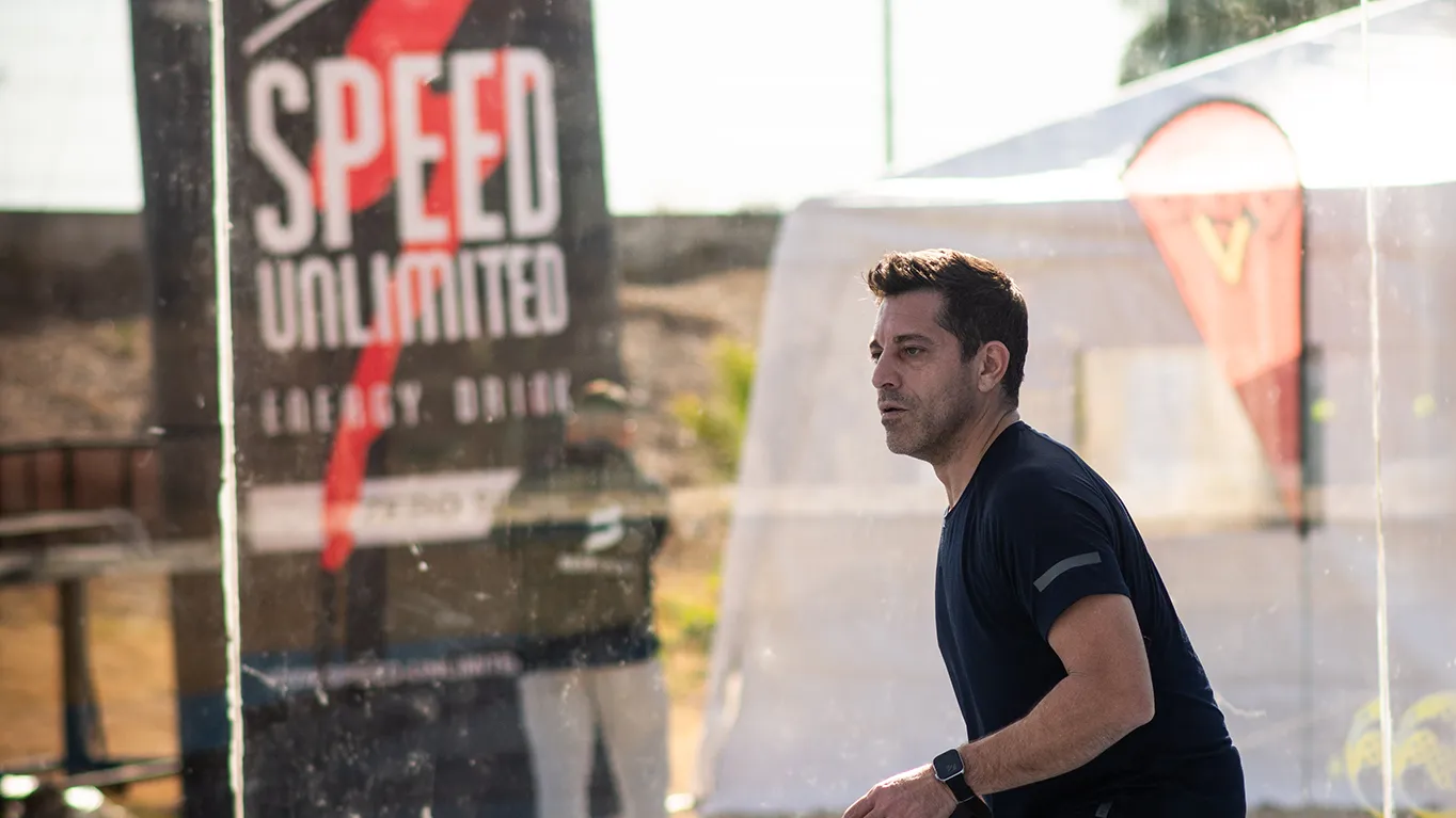 Jugador compitiendo con banner de Speed Unlimited visible, mostrando integración de marca en el evento